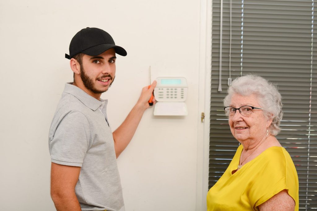 Installation d’une alarme maison sans fil avec clavier de commande et détecteur fixés dans une entrée.