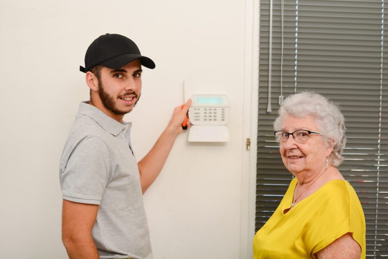 Installation d’une alarme maison sans fil avec clavier de commande et détecteur fixés dans une entrée.